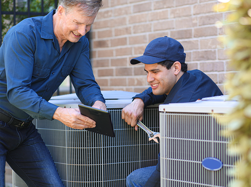 Technicians installing air conditioning unit